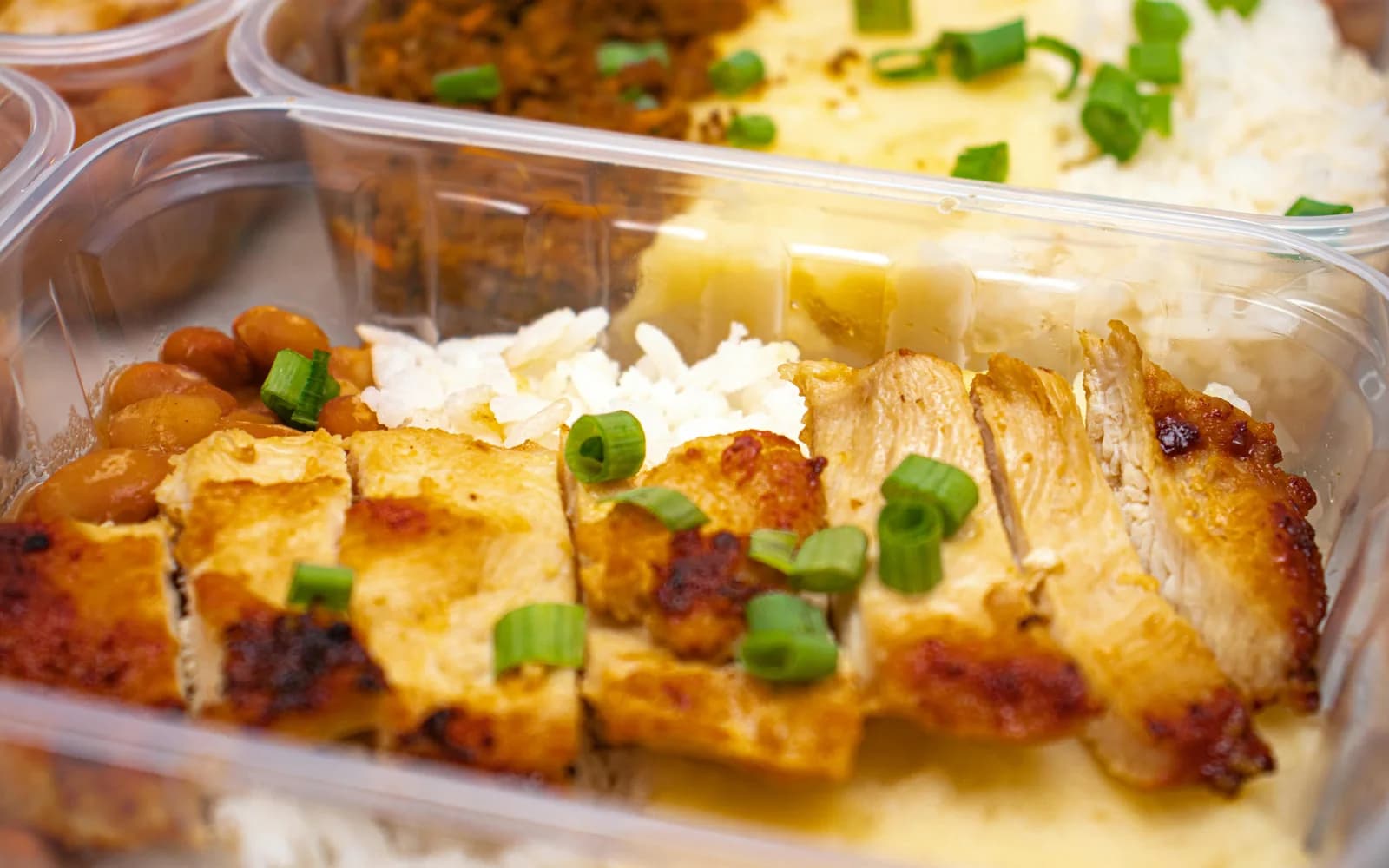 Meal-Prep-Box mit Hähnchen, Reis und Gemüse in sauberer, klarer Wochenplan-Optik.